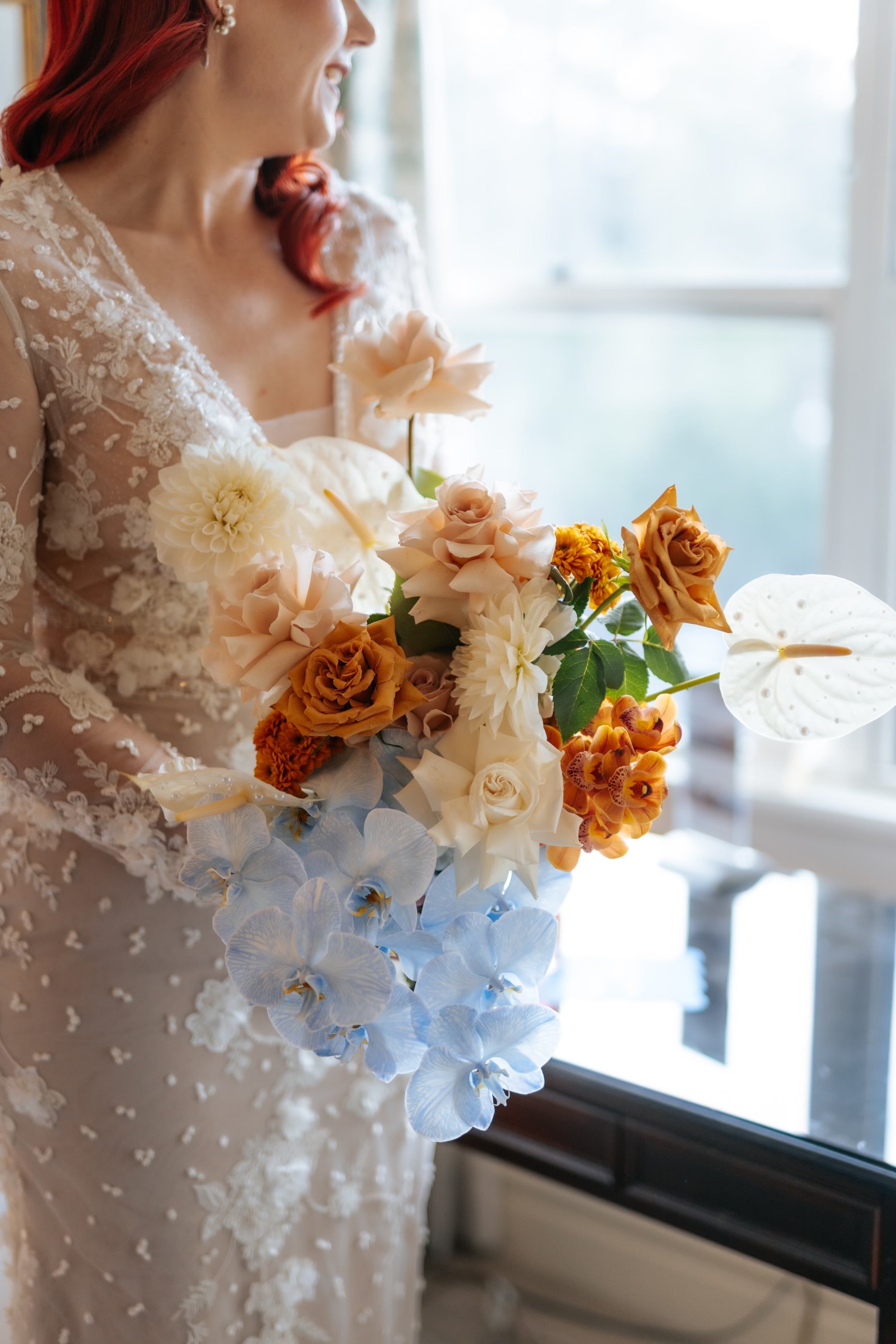 Bride on wedding day holding an artistic modern bouquet with premium flowers including orchids, roses, dahlias, and lilies by Posy Central by Western Sydney florist